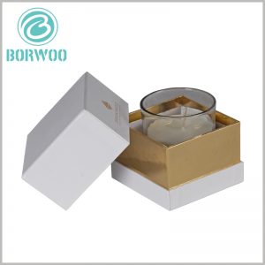 White square cardboard boxes for candle packaging. Small cardboard boxes have lids, and the inner neck of the packaging uses gold cardboard as laminated paper. The packaging has a luxurious visual sense.